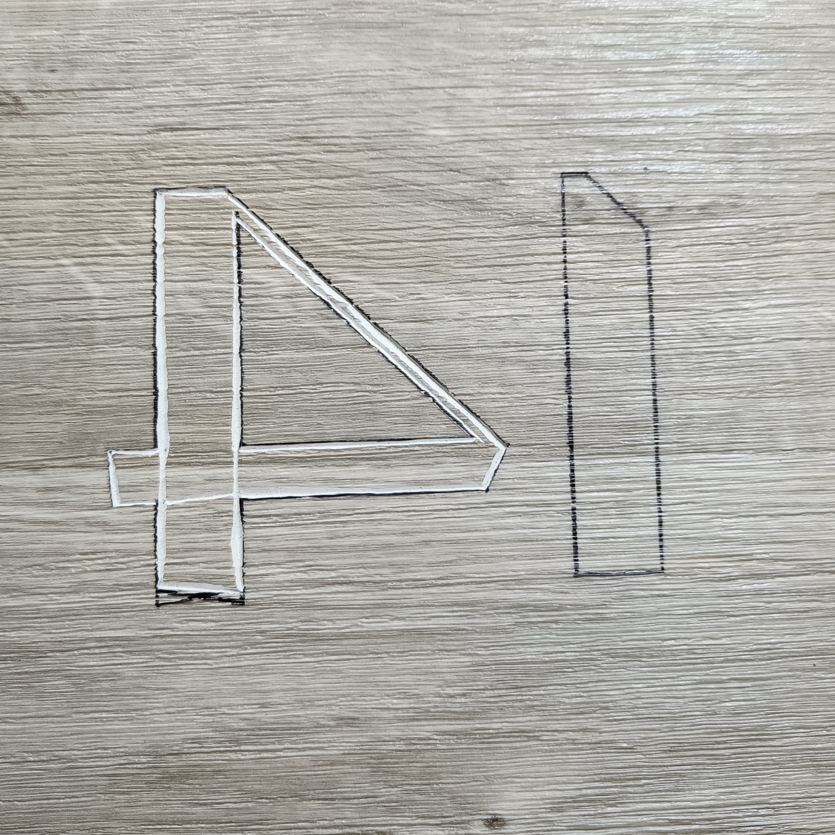 A «14» mirrored in outline on a piece of bathroom floor
  vinyl. The first cuts have been made into the lino to outline
  the figure 4.